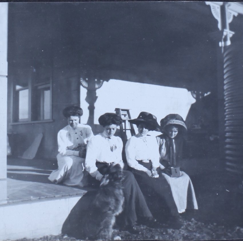 Four women on a verandah with a dog