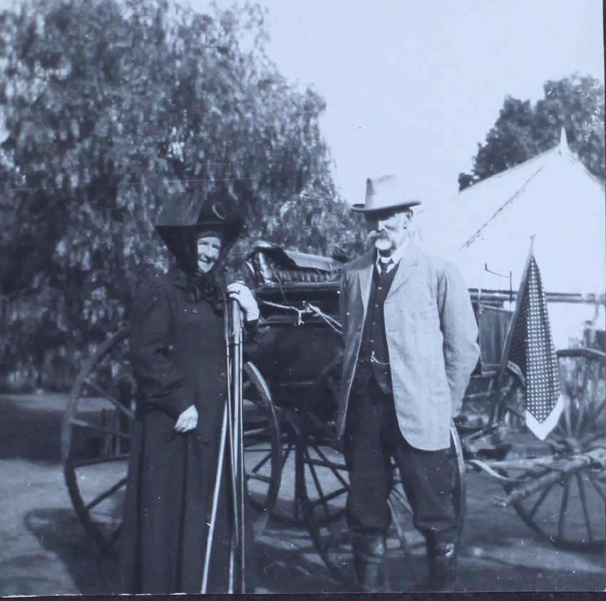 Unidentified couple standing beside a buggy