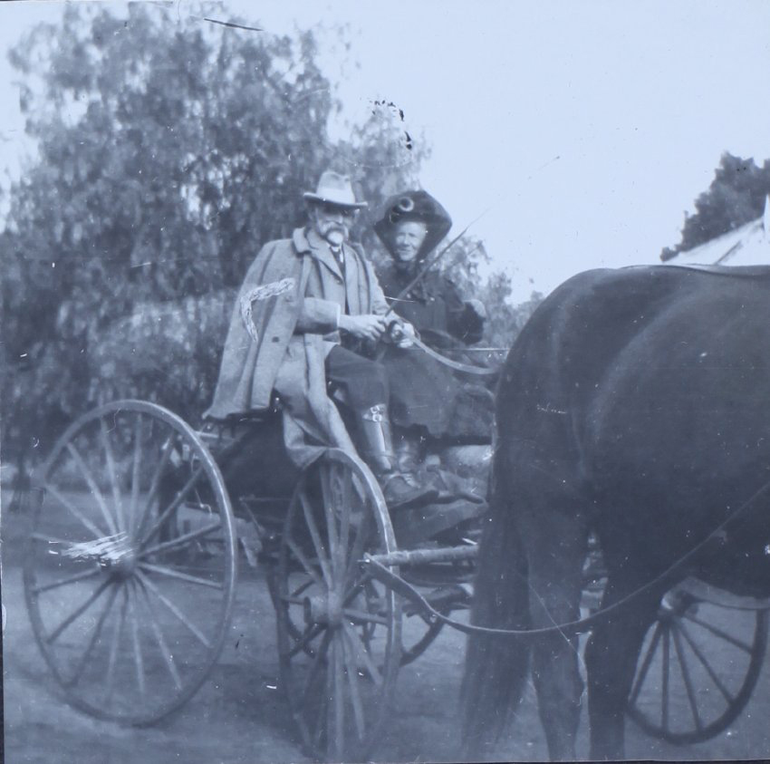 Unidentified couple sitting in a buggy