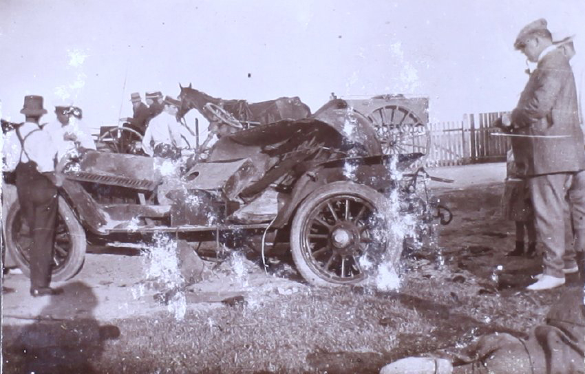Unidentified men standing around a wrecked car