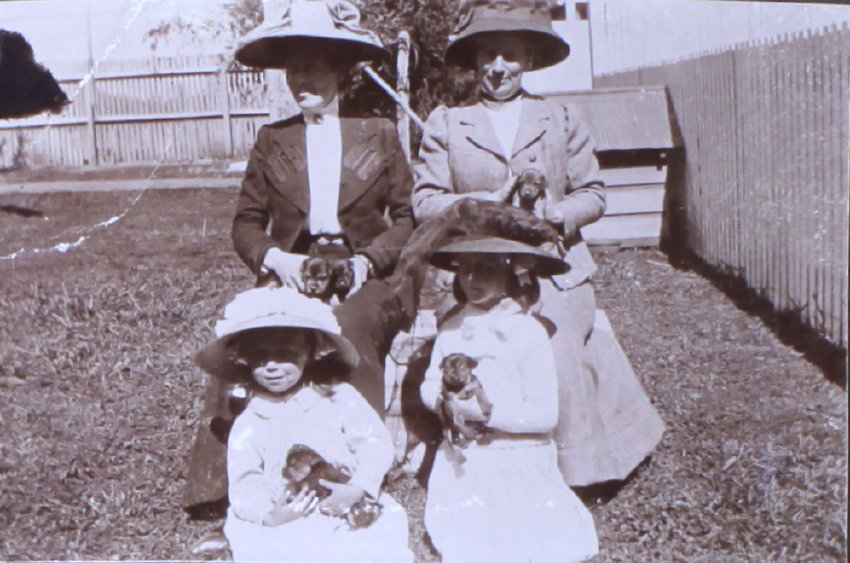 Two unidentified women and two girls all holding puppies