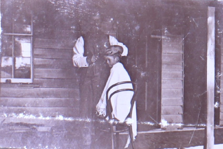 Unidentified man with a boy getting a haircut