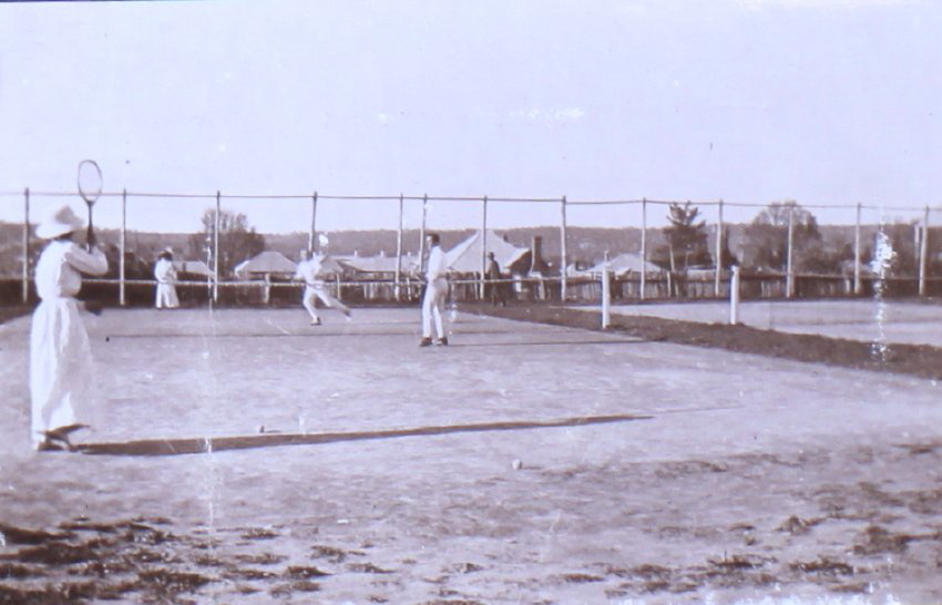 Two undentified man and two women playing tennis