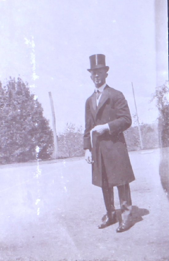 Unidentified man in top hat long coat