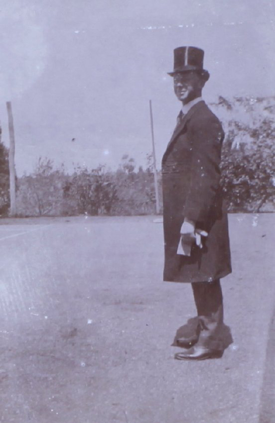 Unidentified man in top hat long coat