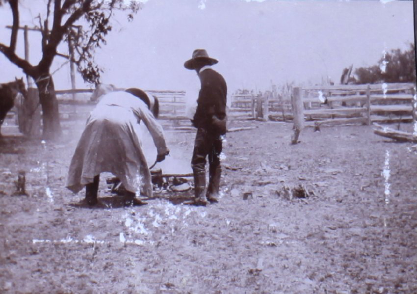 Two unidentified men tending a fire