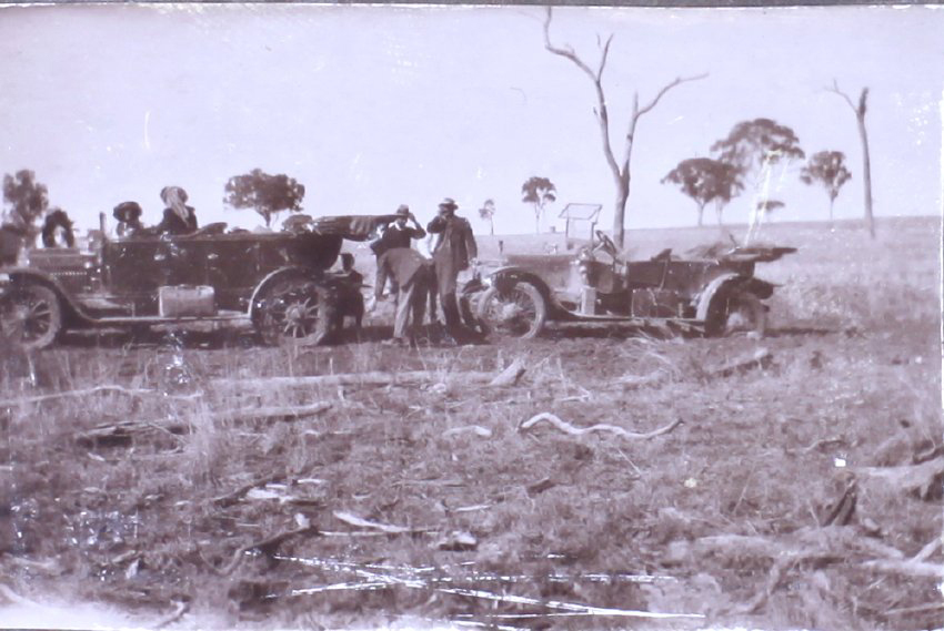 Unidentified men and women with two cars