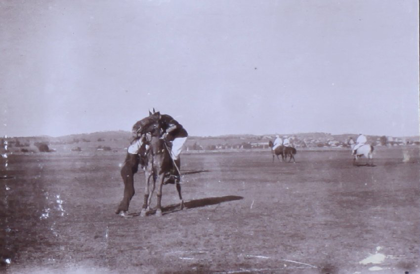 Jockey mounting a racehorse with assistance from a handler