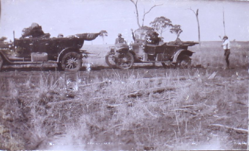 Unidentified people pulling out a bogged car with another car