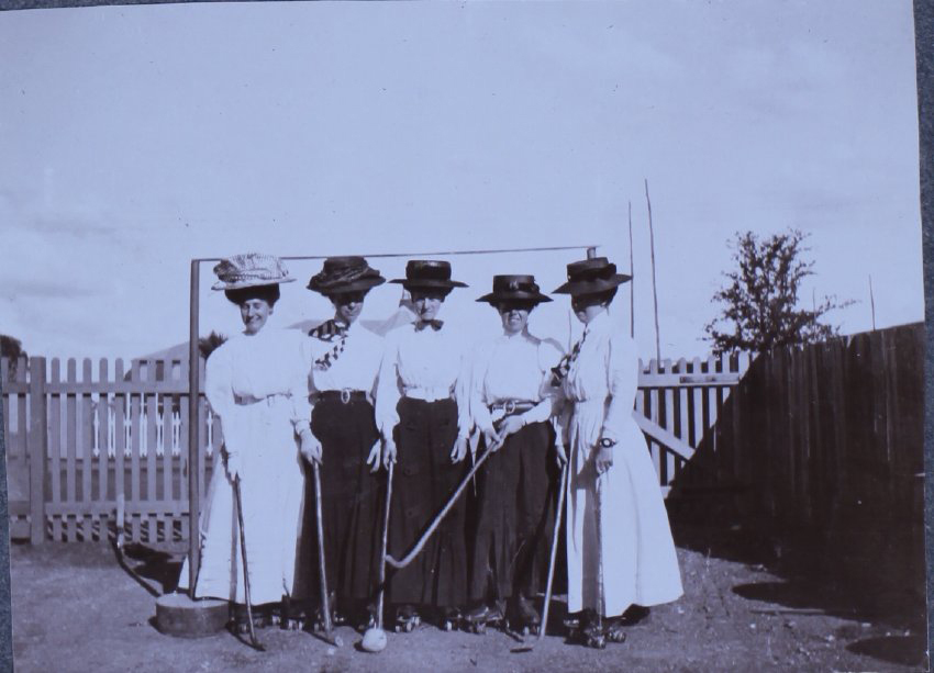 Five women with hockey sticks on rollers skates