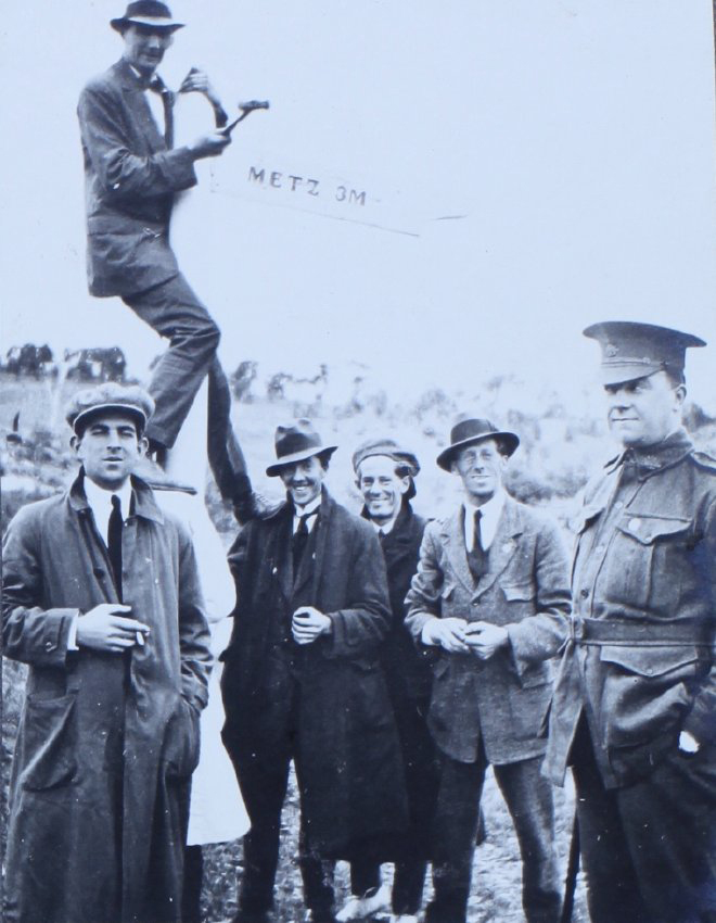 Six men (one in uniform) at Metz sign, east of Armidale, NSW