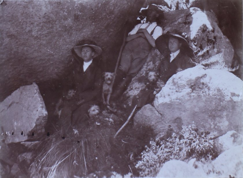 Three people sitting among rocks