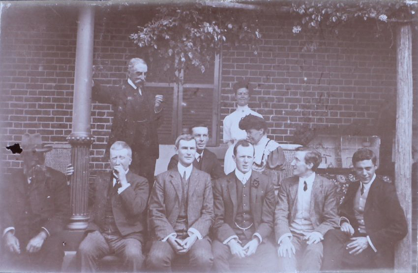 Group of eight men and two women on verandah