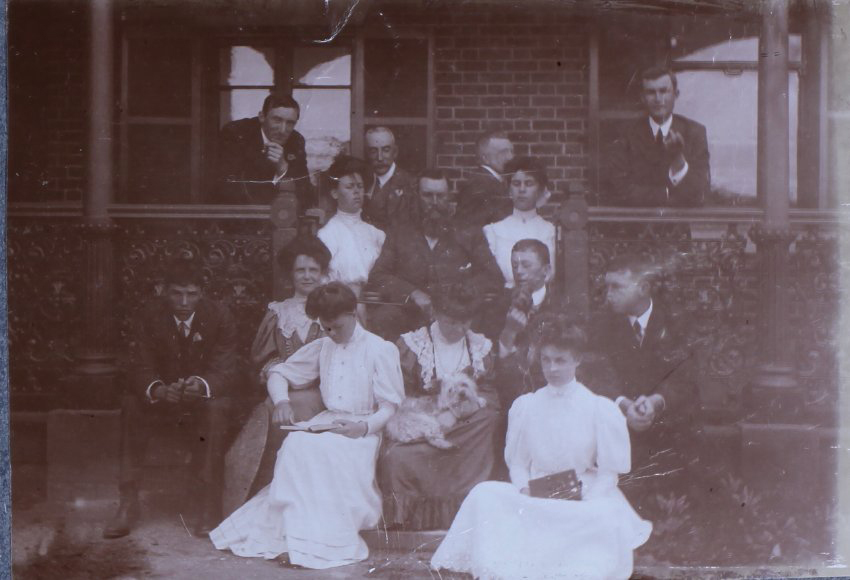 Group of eight men and six women on verandah