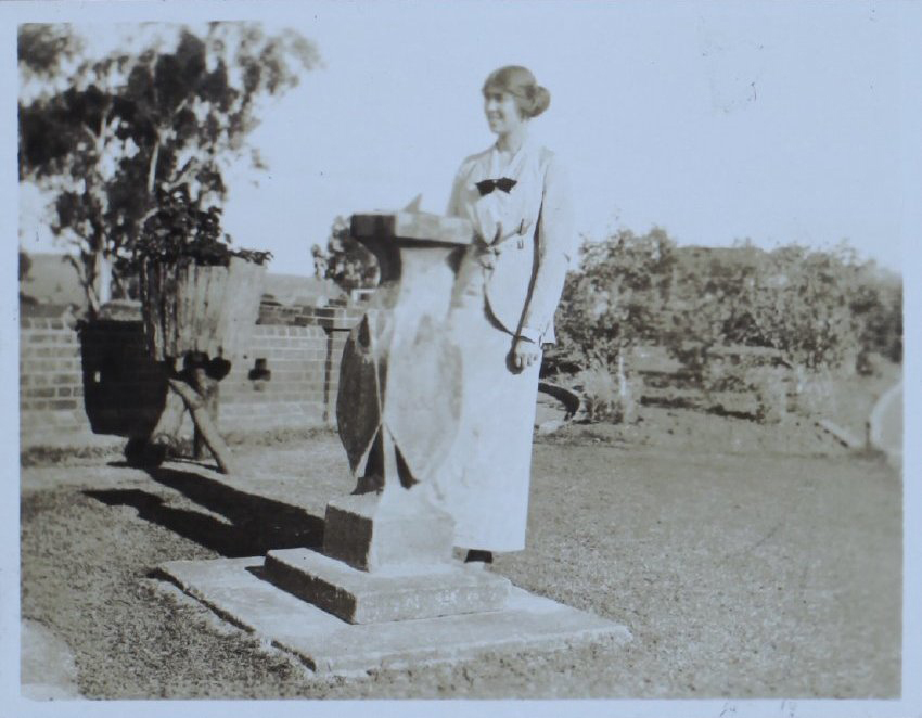 Woman standing beside a sundial