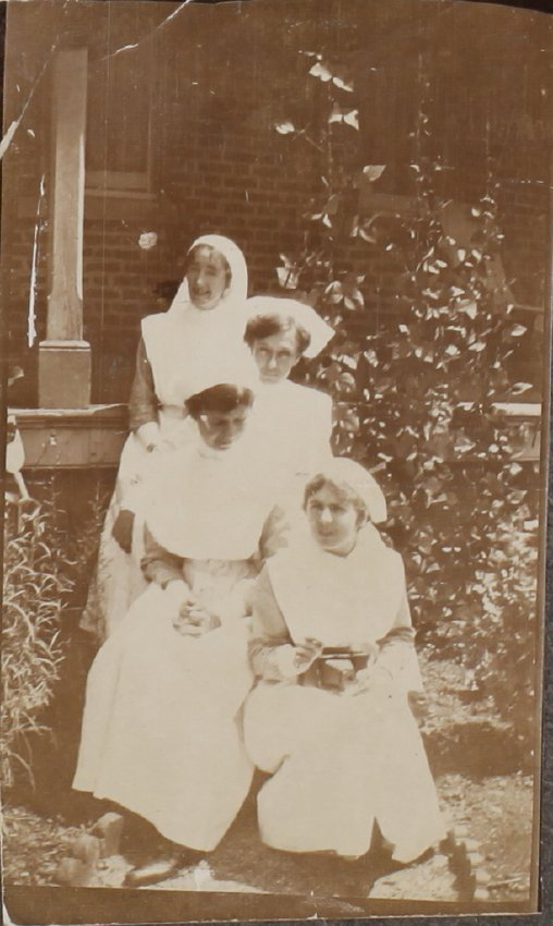 Four nurses in front of unidentified building