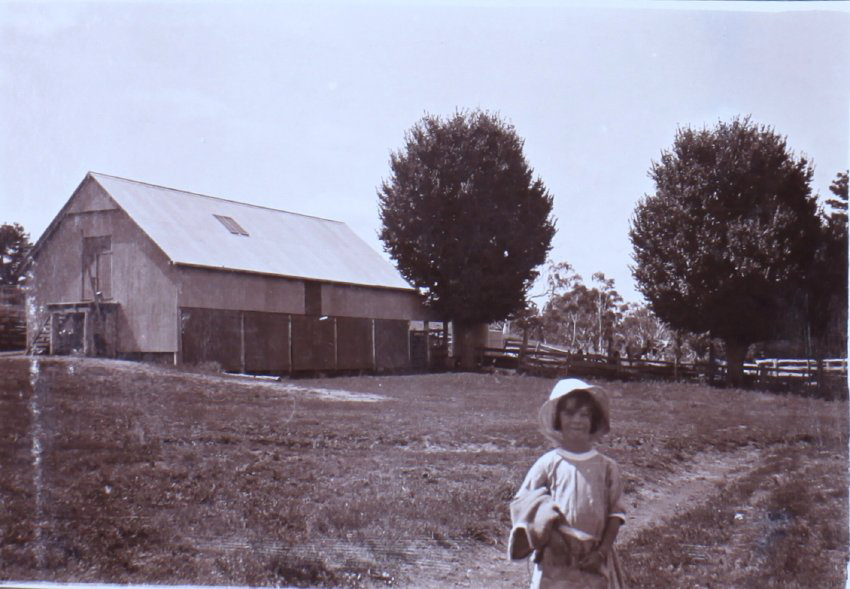 Unidentified child and farm buildings