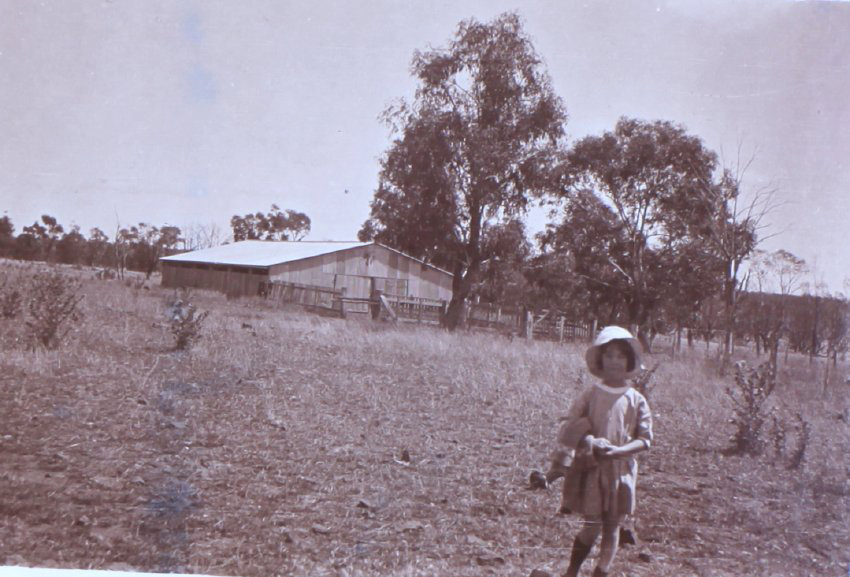 Unidentified child with farm building