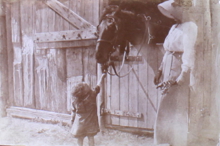 Unidentified woman and child with a horse