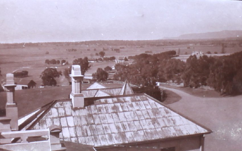 View of rooftop and farmland beyond