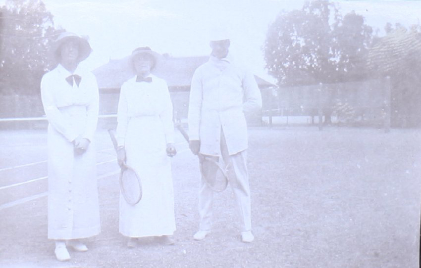 Two unidentified women and one man ready for tennis