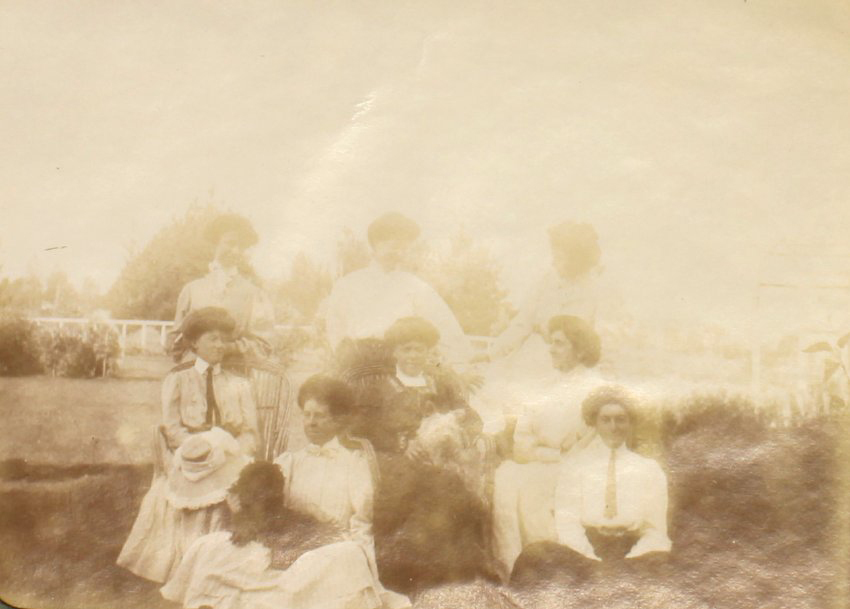 Eight unidentified women in a garden with pet dogs