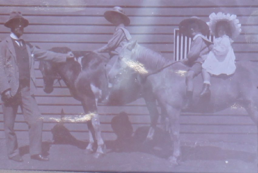 Unidentified children on horseback with man
