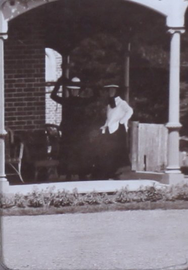 Two unidentified women on the verandah of a house