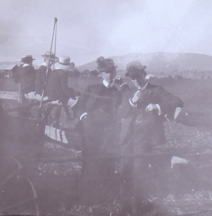 Two unidentified men with three boys sitting on the rails behind them