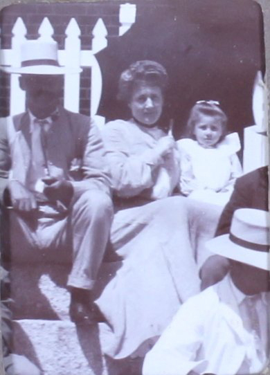 Unidentified man, woman and child on steps