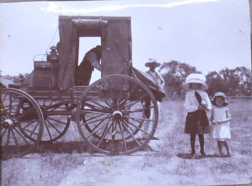 Two unidentified children behind a wagon