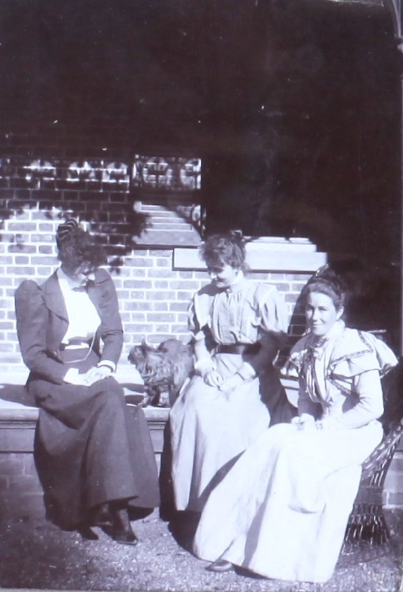 Three unidentified women with a pet dog