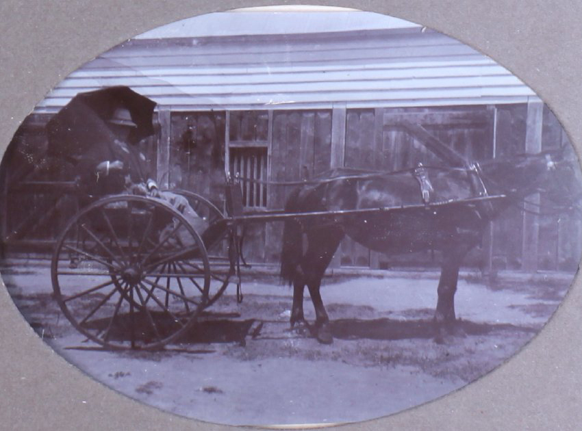 Unidentified man in a buggy outside a building