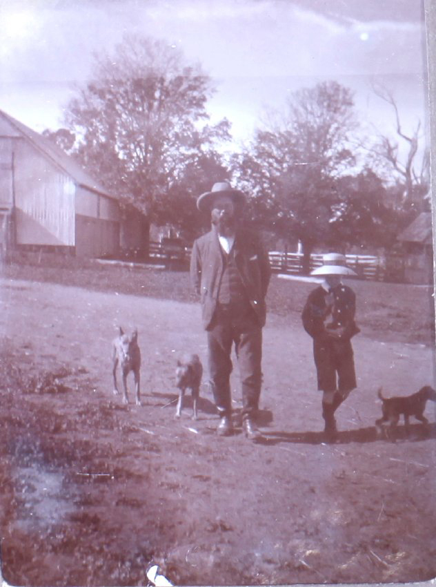Unidentified man and boy with pet dogs