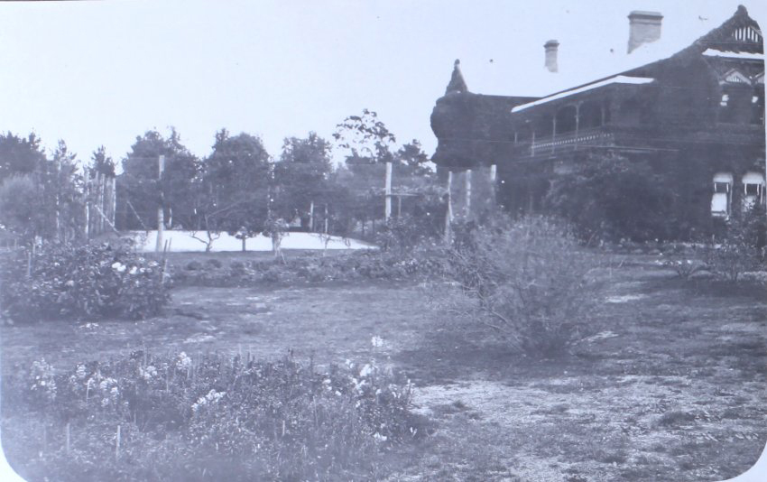 View of gardens, tennis court and house