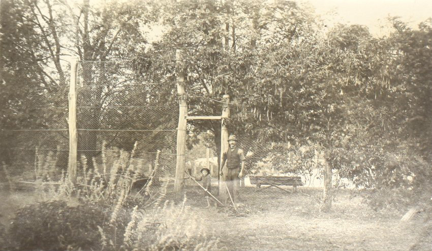 Unidentified man and young boy working in the gardens