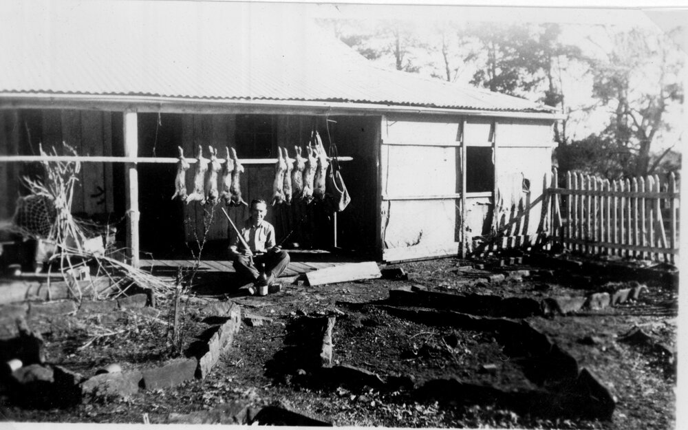 Sitting on house verandah with skinned rabbits