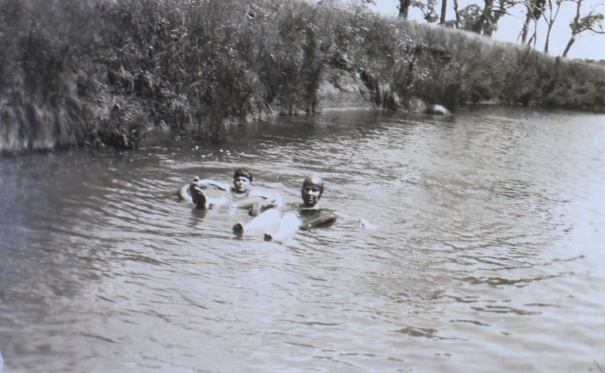 Group of unidentified swimmers in a creek