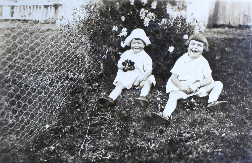Two unidentified children sitting on the lawn