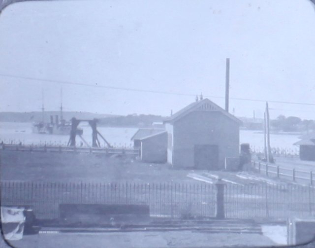 Unidentified harbour with ship leaving