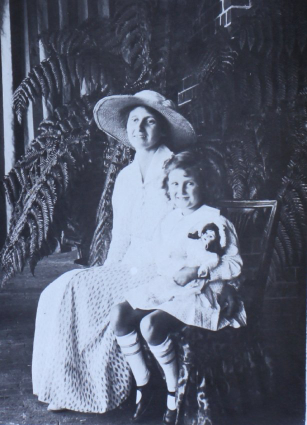 Unidentified woman and child sitting in a fernery