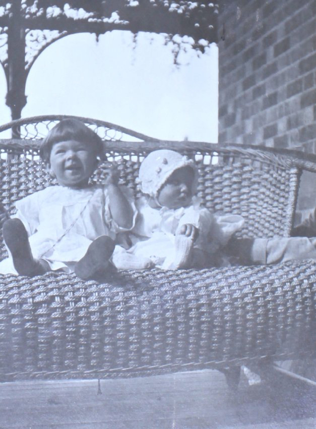 Two unidentified children sitting on a lounge