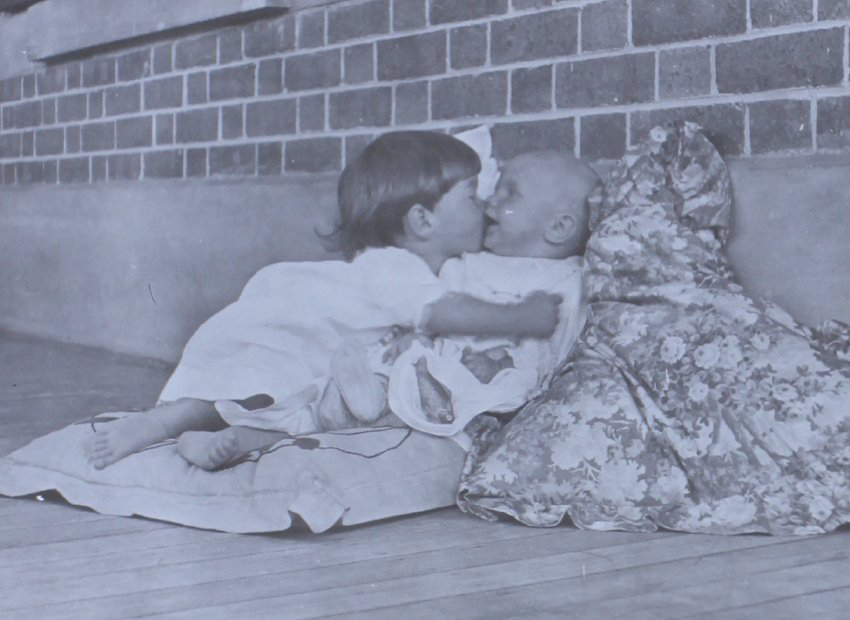Two unidentified children sitting on cushions