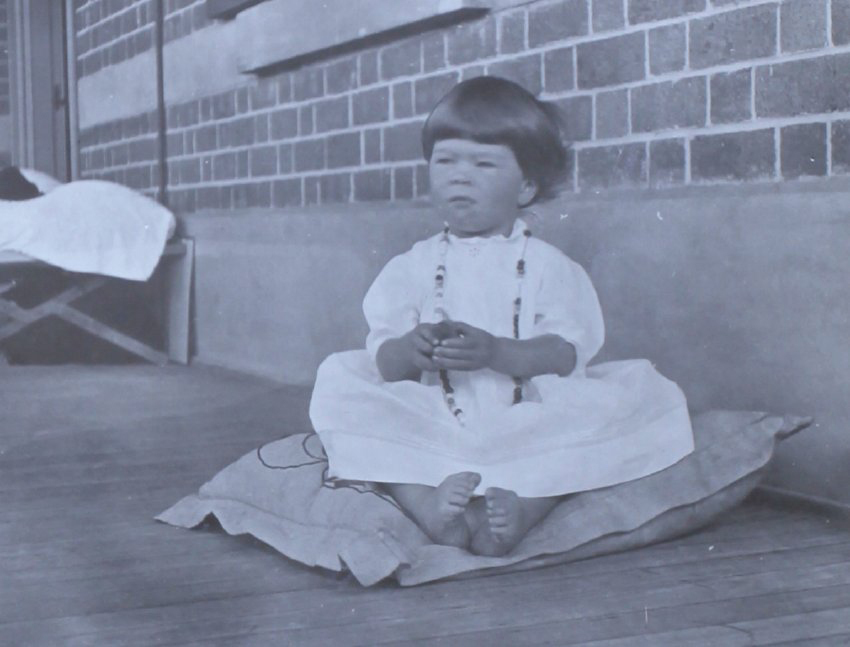 Unidentified girl sitting on a cushion
