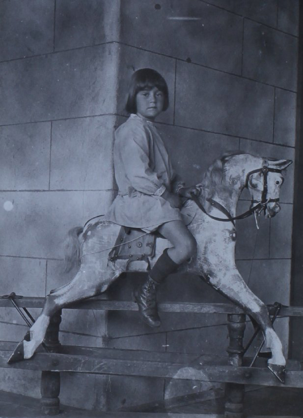 Unidentified young girl on a rocking horse