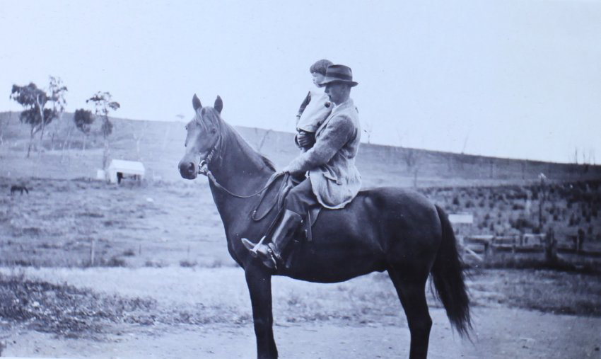 Man holding a child on a horse