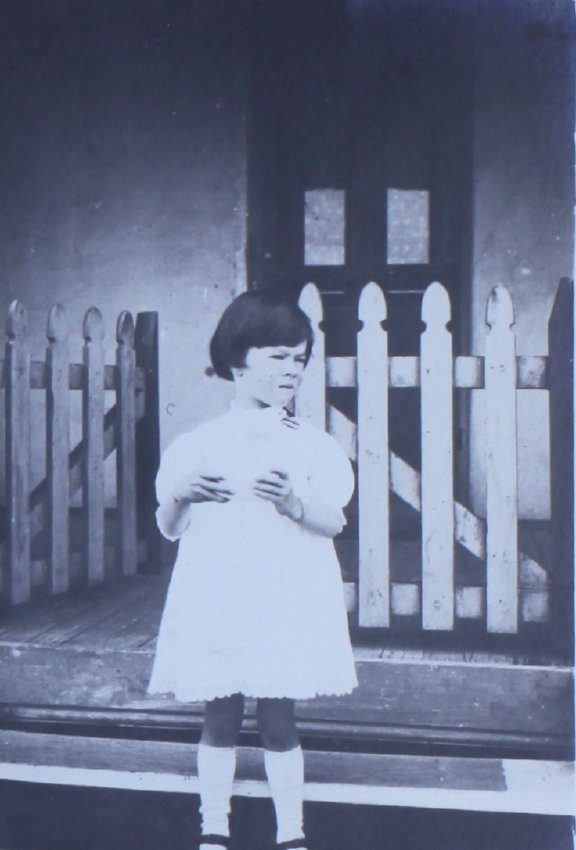 Young girl standing outside a house