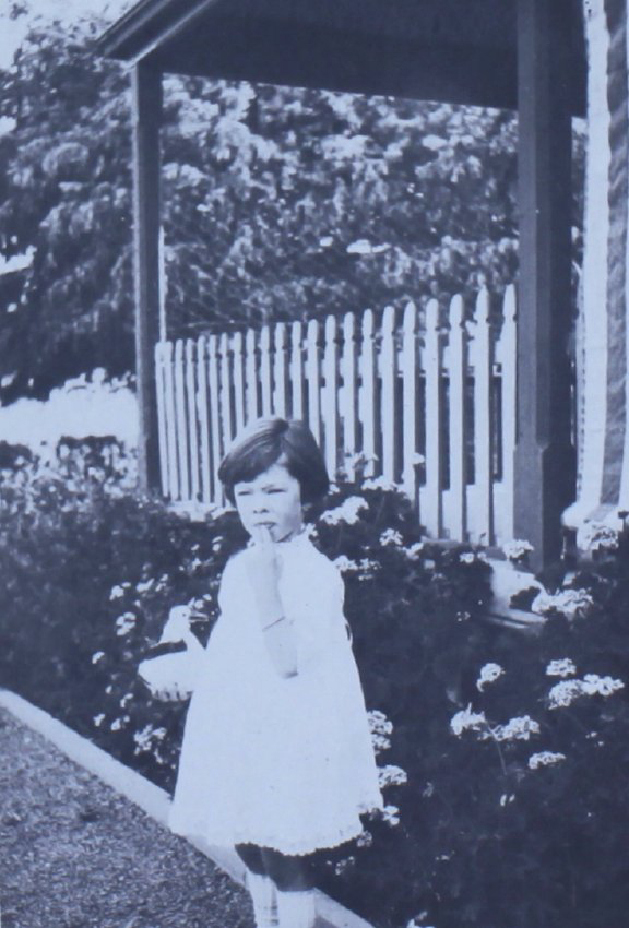 Young girl standing near a flower bed