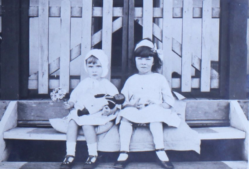 Two young girls sitting on a step