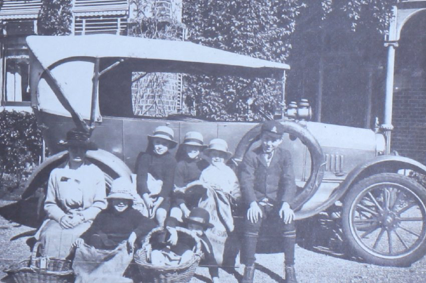 Group of children and an woman sitting on a car